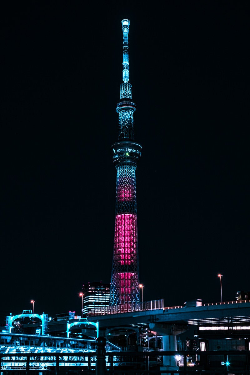「暗闇に浮かび上がるライトアップされた東京スカイツリー」の写真