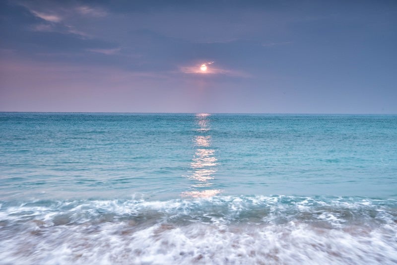 青い海に映える太陽の写真