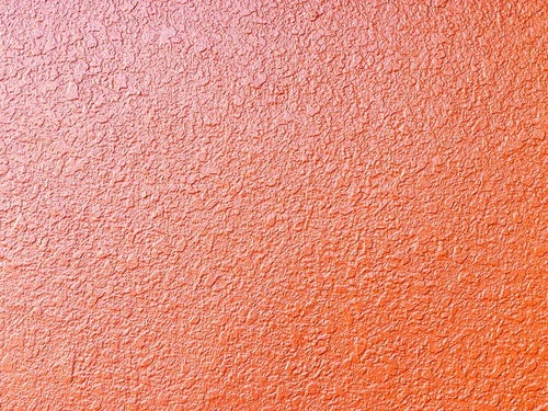 オレンジ色のモルタル壁のテクスチャーの写真