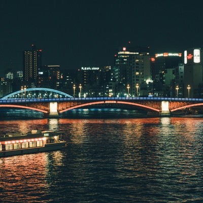 ライトアップされた橋と水上バス（隅田川）の写真