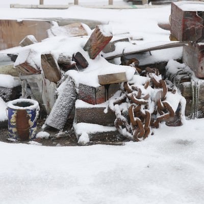 錆び付いた鎖と廃材に積もる雪の写真