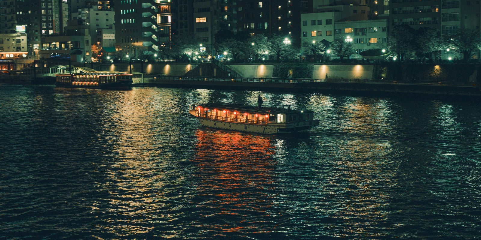 「隅田川に浮かぶ屋形船と水上バス」の写真