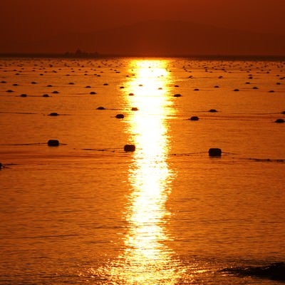 海に伸びる夕暮れのレイラインの写真