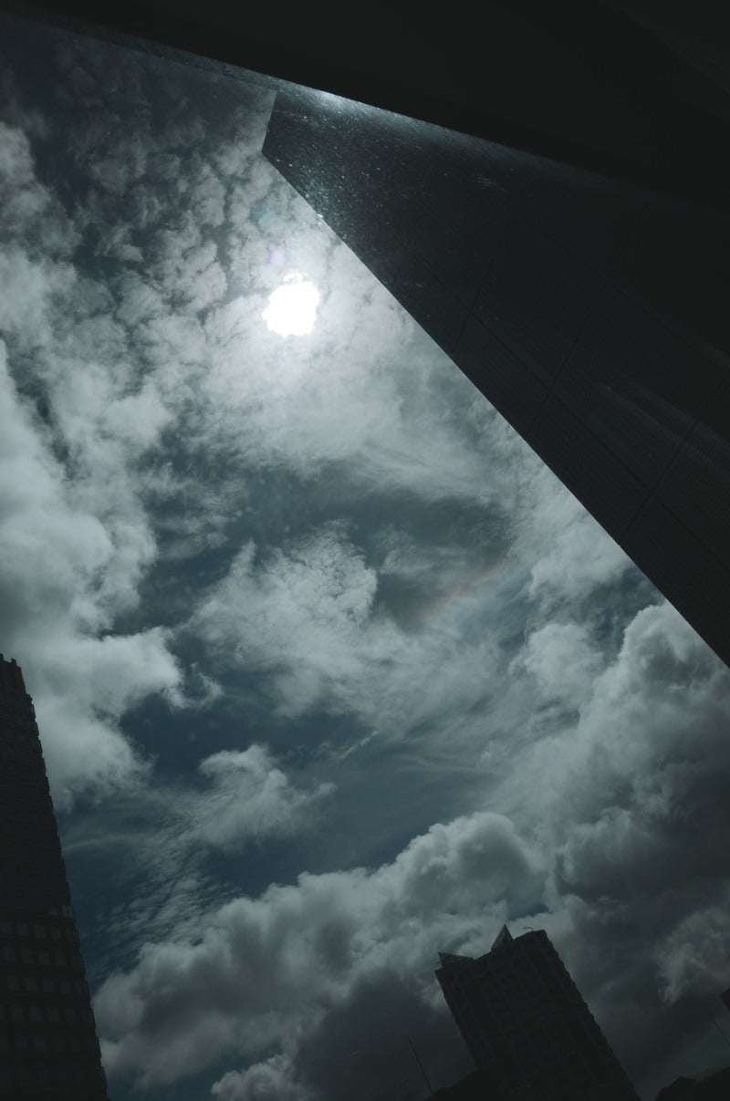 「ビル隙間から見上げある空の様子」の写真