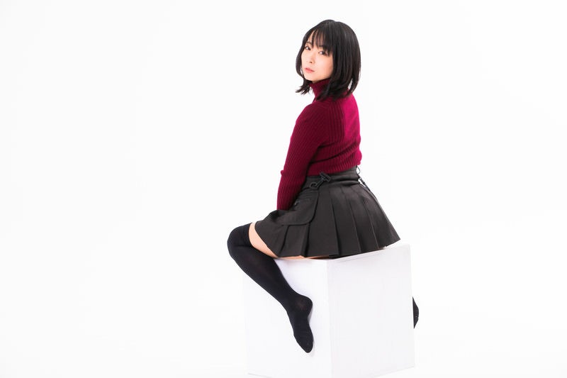 白い箱に跨って振り返る女性