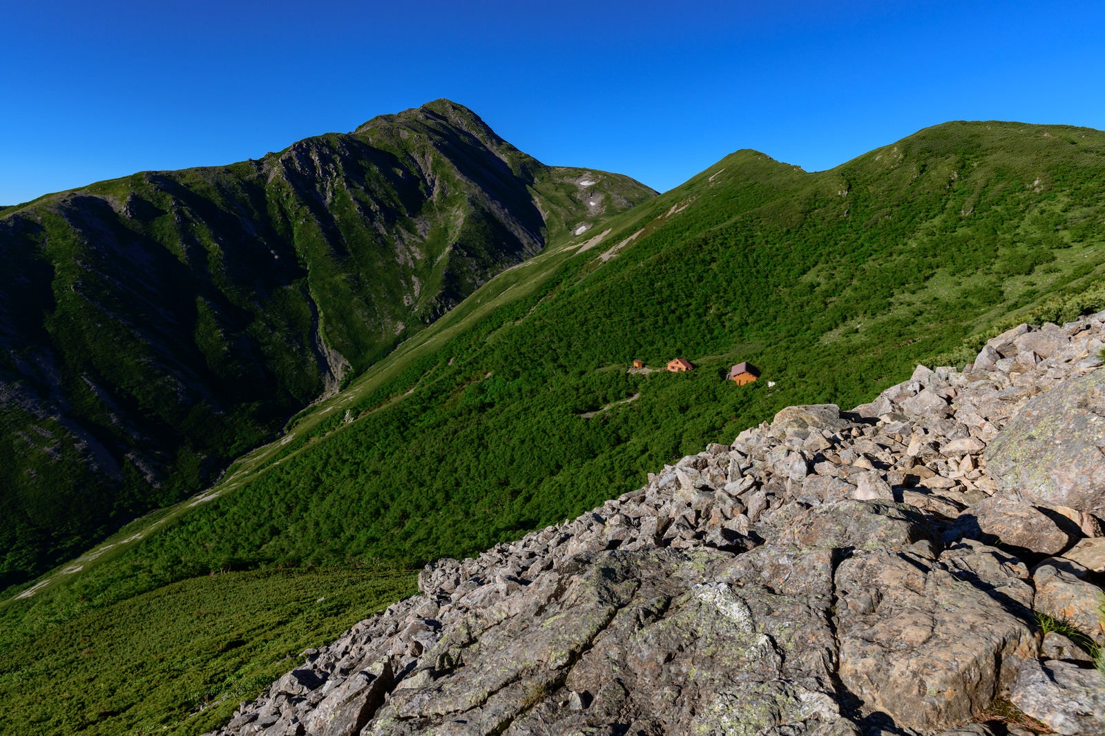 「傾斜に立つ山小屋と赤石岳（南アルプス）」の写真