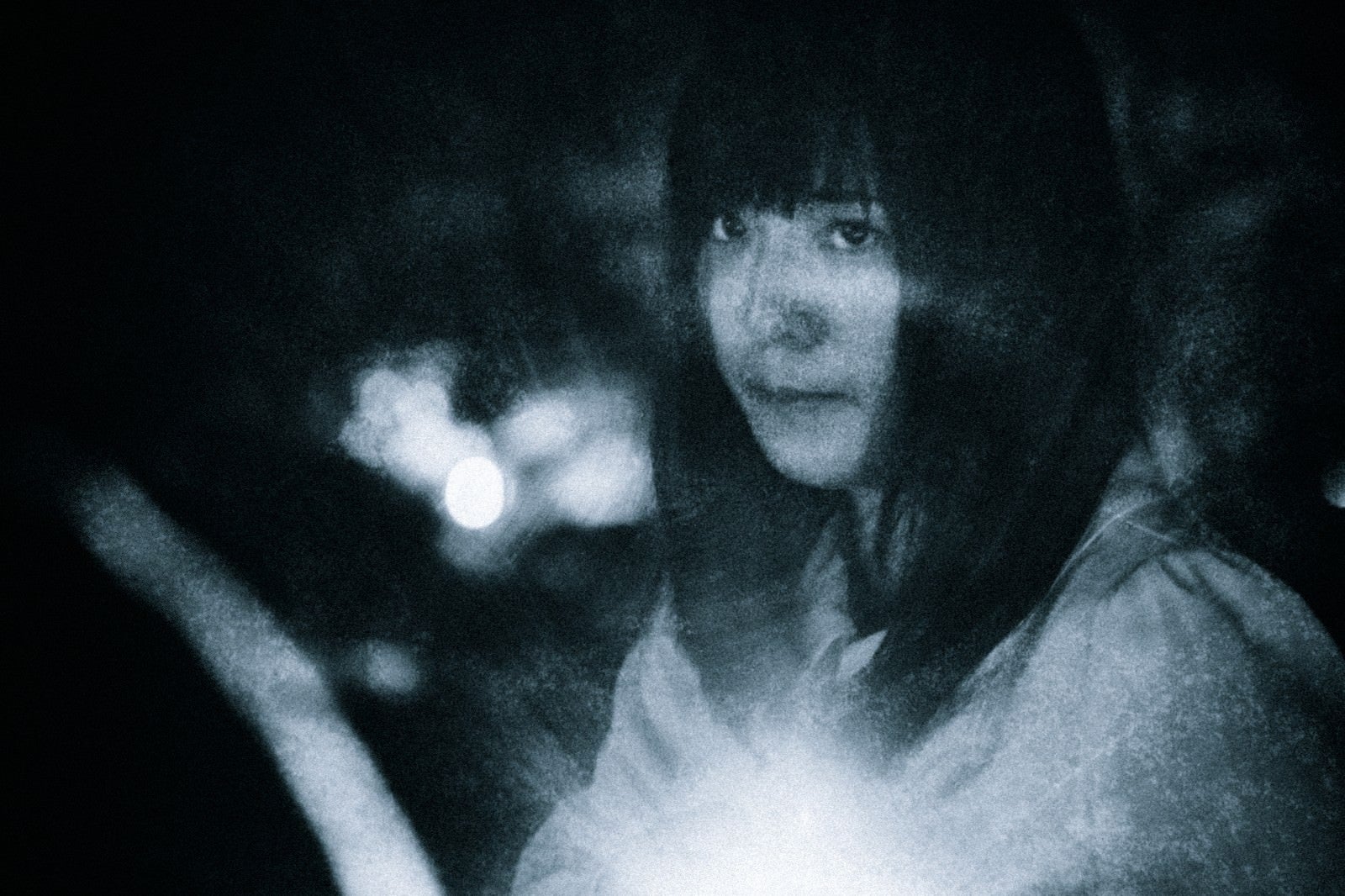 「不安な面持ちで暗闇を進む女性」の写真［モデル：さとうゆい］