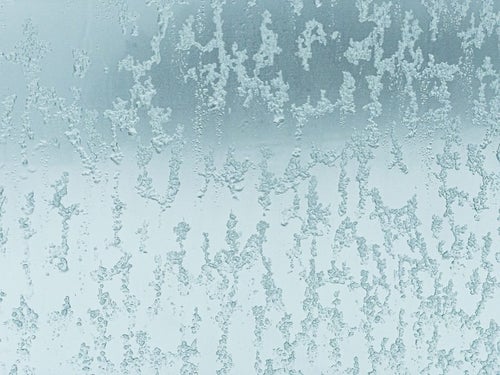 窓ガラスに残る溶けた氷のテクスチャーの写真