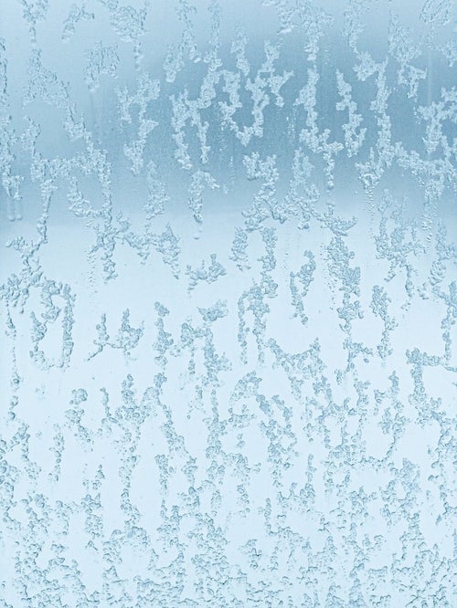 窓ガラスに残る溶けかけた雪のテクスチャーの写真