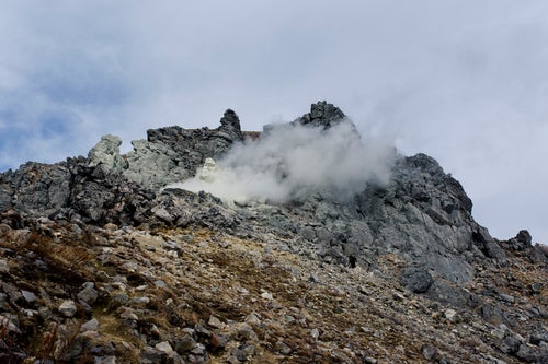 噴気を上げる焼岳（やけだけ）の写真
