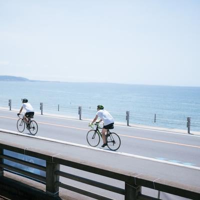 海岸沿いの風を感じるロードバイクサイクリングの写真