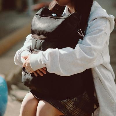 抱えたリュックが語る青春の静かな瞬間の素材