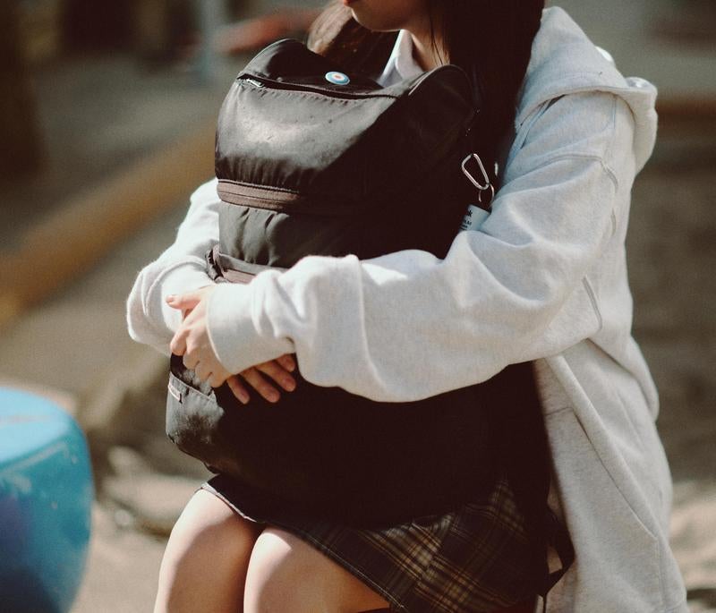 抱えたリュックが語る青春の静かな瞬間の写真