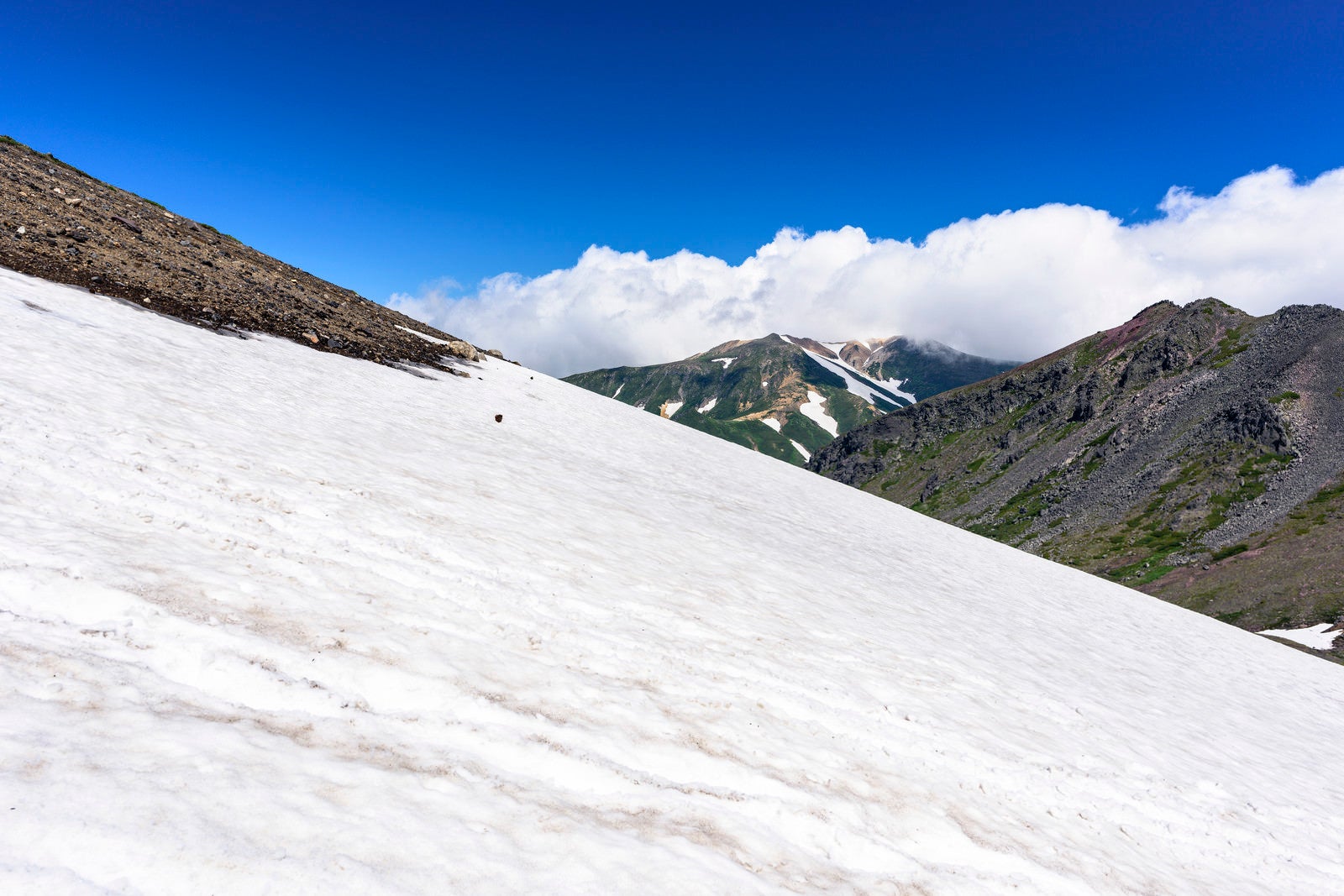 「夏でも雪渓が残る旭岳（あさひだけ）」の写真