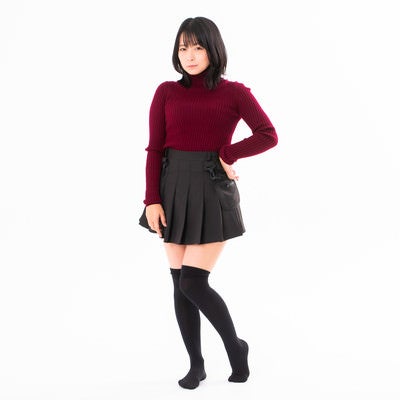 腰に手を当てポージングするニーハイ女性の写真