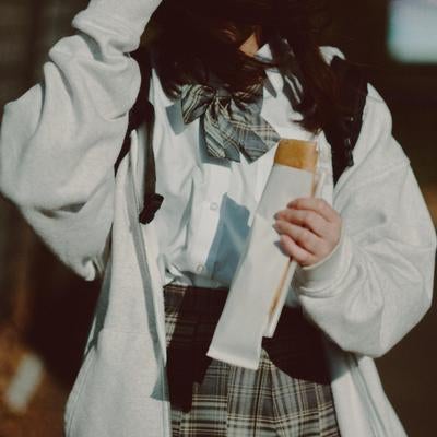 放課後に軽食とともに過ごす女子高生の写真