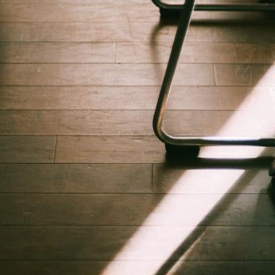 木製のフローリングと金属製の脚の一部の写真