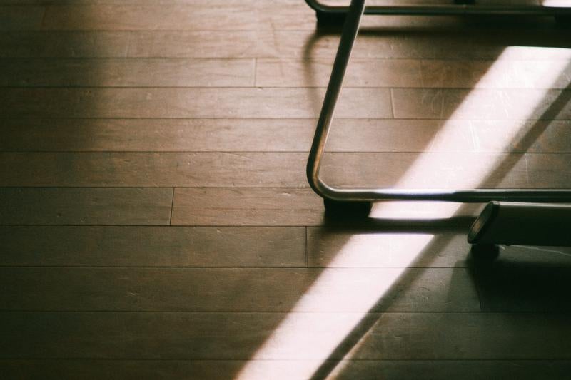 木製のフローリングと金属製の脚の一部の写真