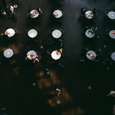 並ぶ丸テーブルと休息する人らの写真