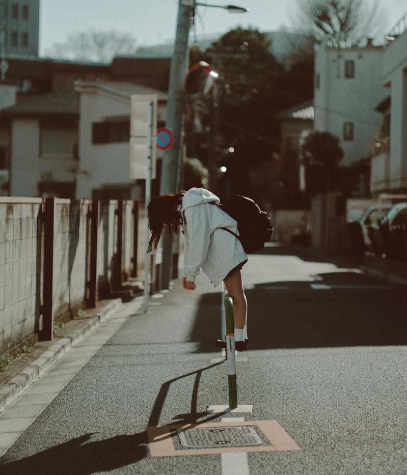 青春の疲れとともに歩む女子高生の通学路の写真