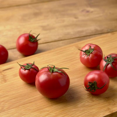 木製まな板の上のミニトマトの写真