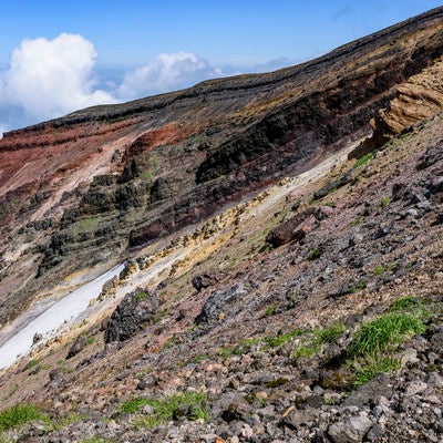 重なり合う地層が見える旭岳の爆裂火口の写真