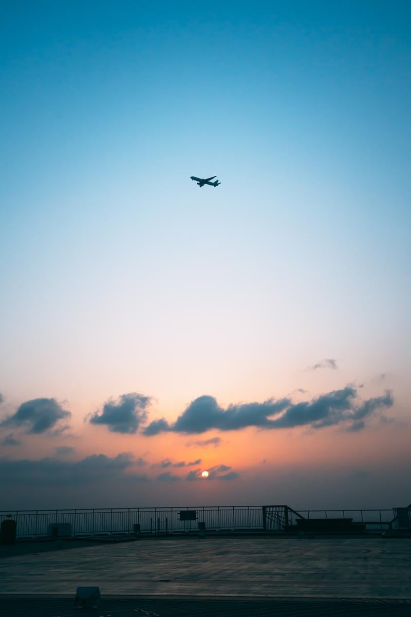「空を彩る夕日と飛行機」の写真