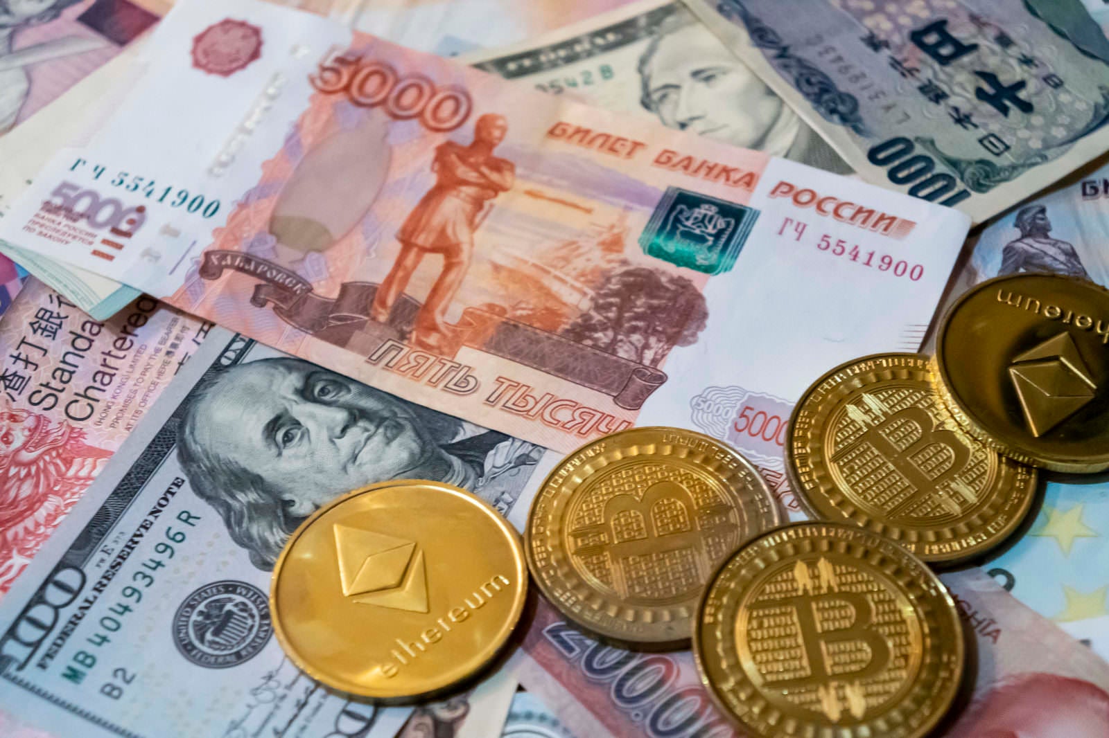 「ロシアルーブルなどの紙幣と暗号通貨（BTCとETH）」の写真