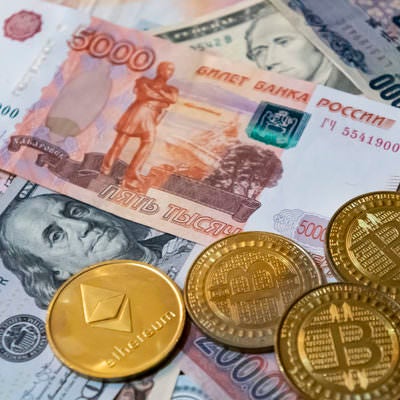 ロシアルーブルなどの紙幣と暗号通貨（BTCとETH）の写真