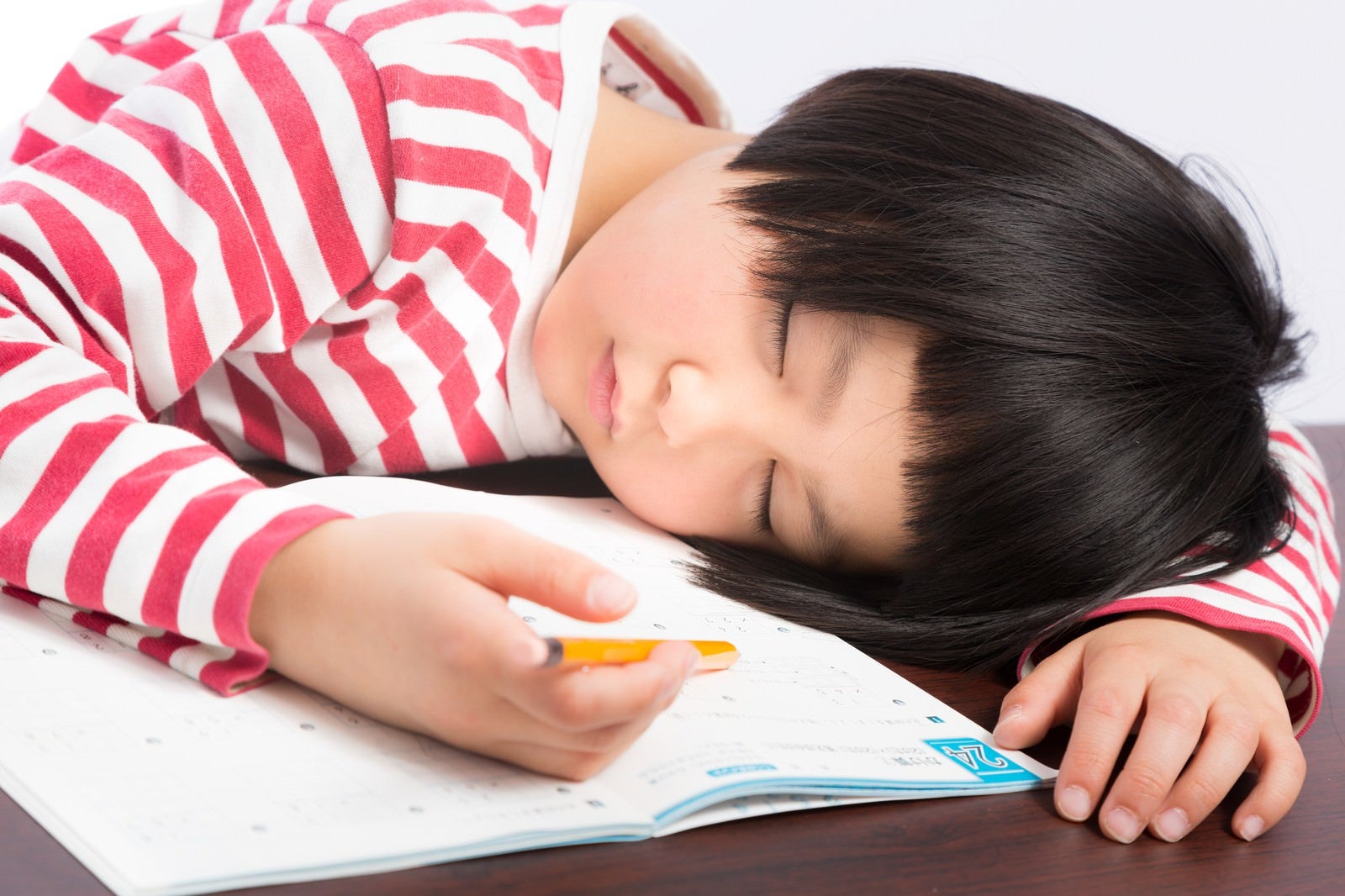 「宿題しながら爆睡する前髪パッツンの女の子」の写真［モデル：ゆうき］