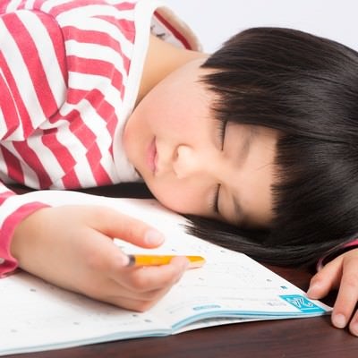 宿題しながら爆睡する前髪パッツンの女の子の写真