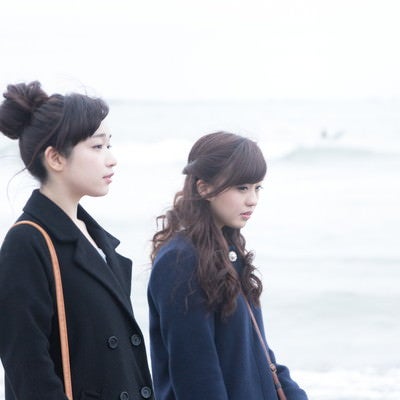 女性二人で冬の海を歩くの写真