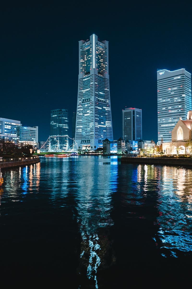 「横浜の夜を彩る水面反射のランドマークタワー」の写真