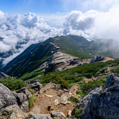 巨大な雲が迫りくる駒峰ヒュッテと稜線の写真
