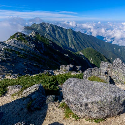 空木岳山頂に落ちている花崗岩と南駒ヶ岳の写真