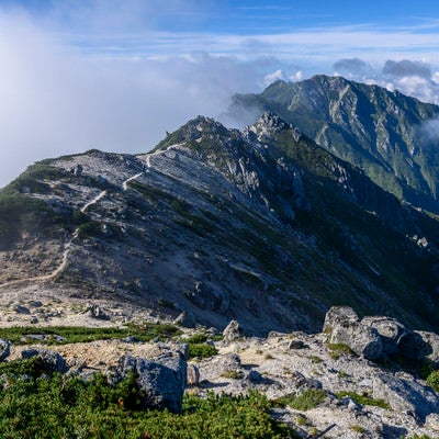 雲が流れゆく南駒ヶ岳方面の登山道の写真