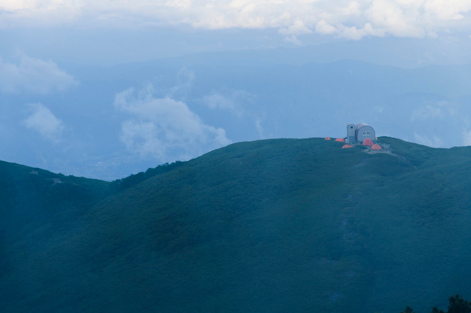 「霧の向こうに立つ檜尾岳の避難小屋」の写真