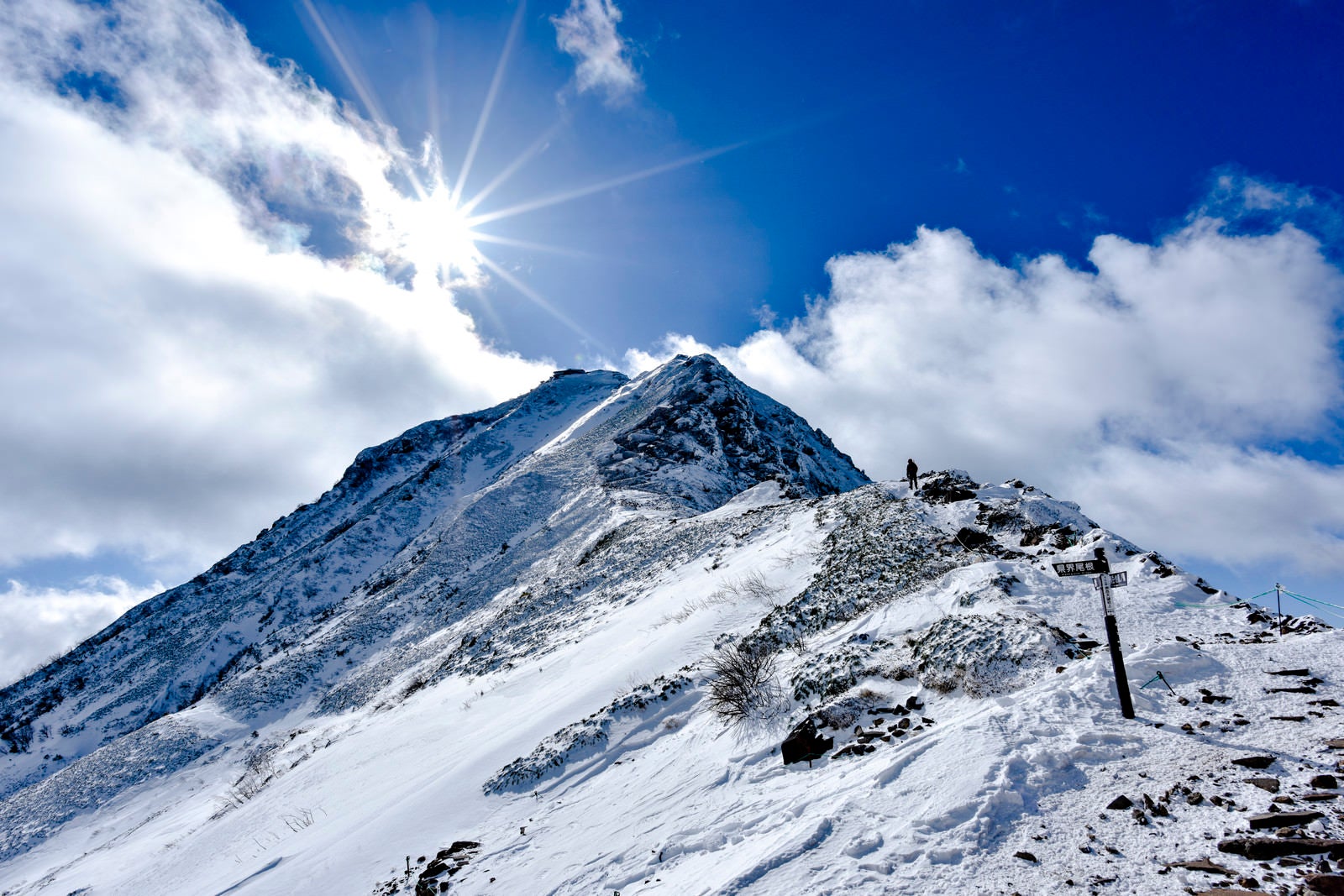 「赤岳山頂の光芒と登山者」の写真