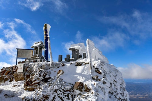 雪に包まれる赤岳山頂の社の写真