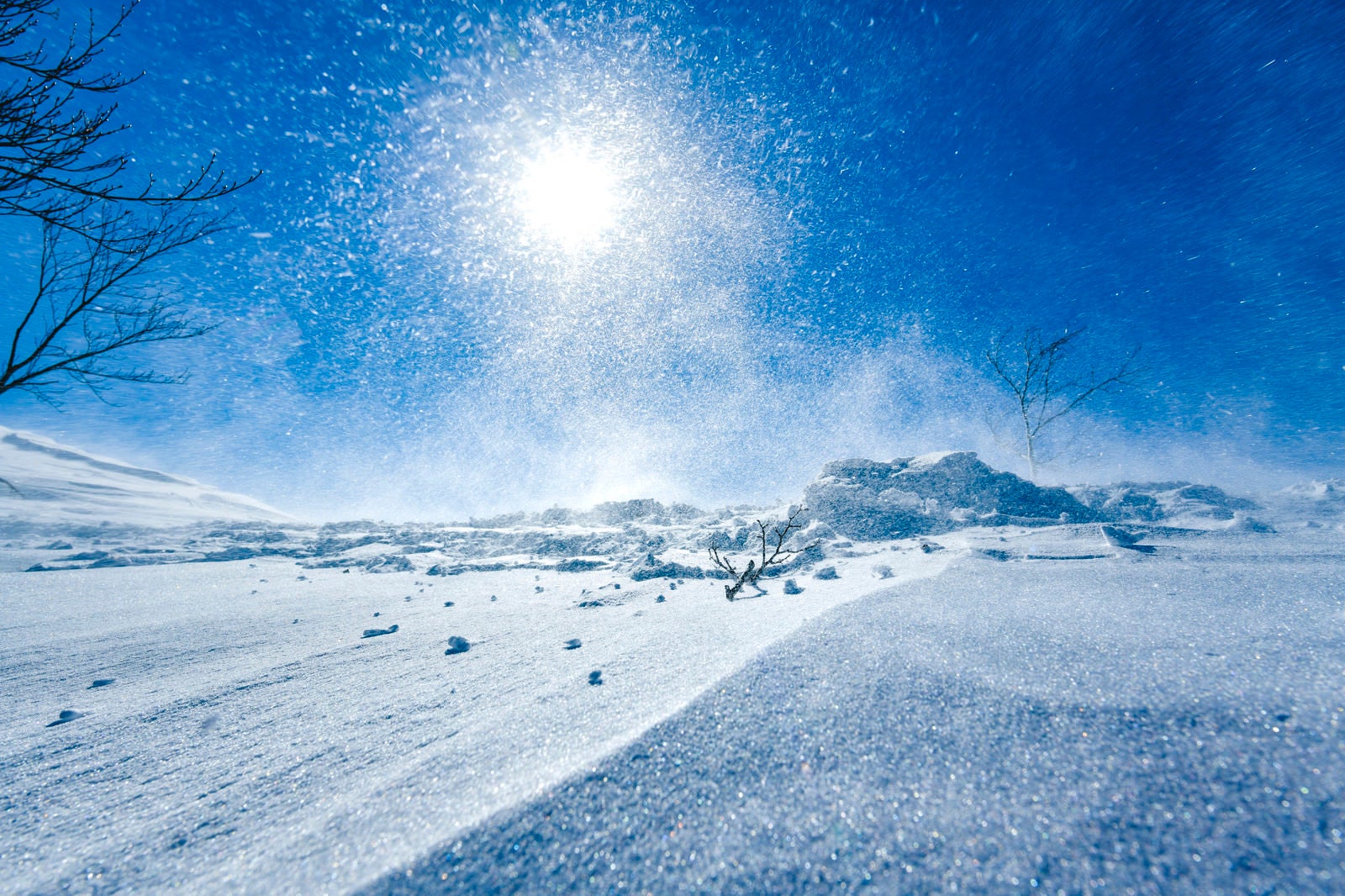 「強風で湧き上がる雪煙と太陽（谷川岳）」の写真