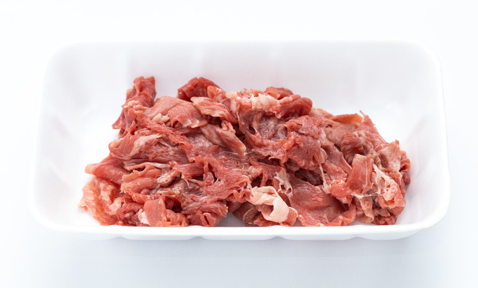 「横向き上から見たトレー入り細切れ肉」の写真