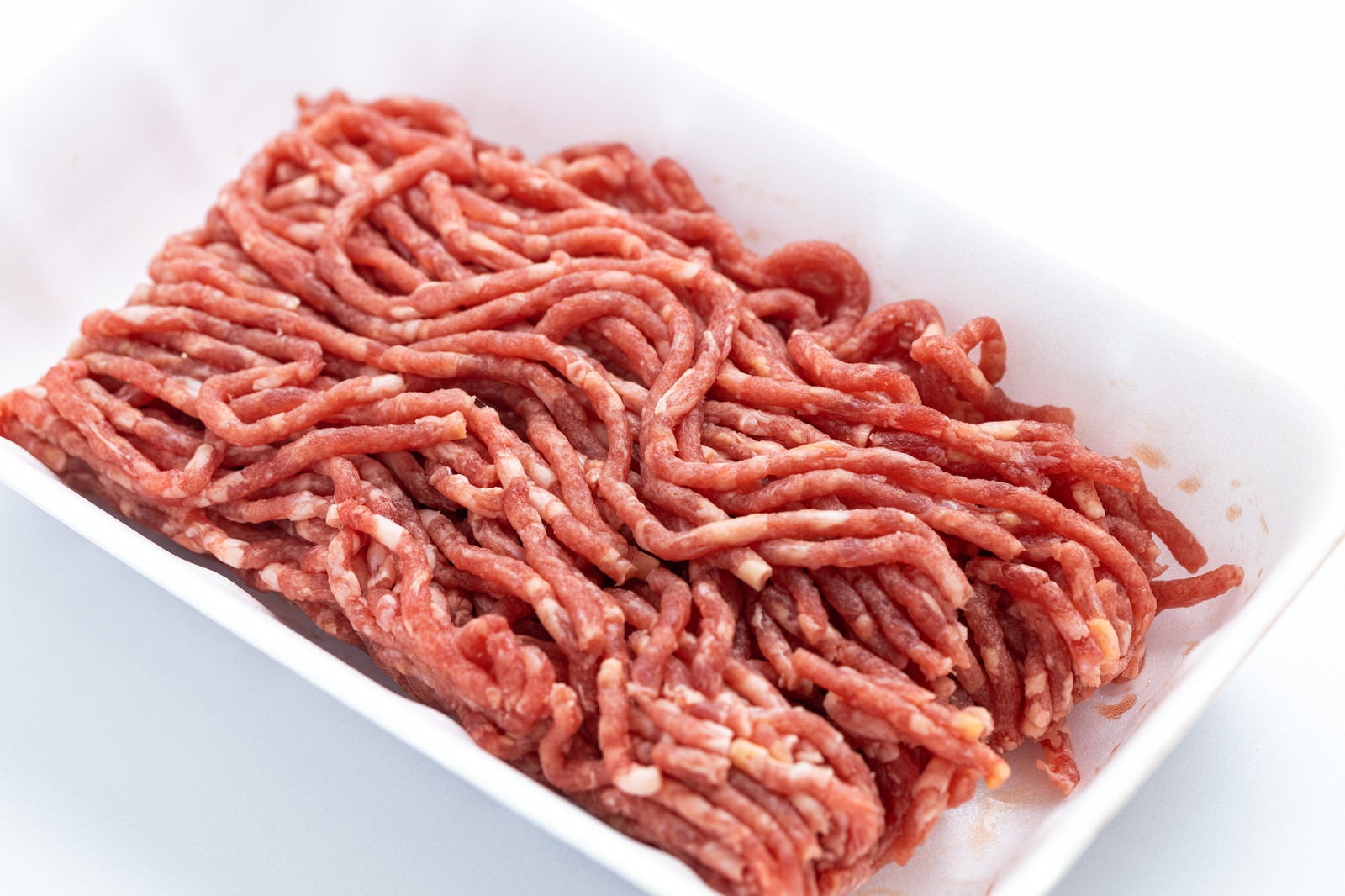 白い食品トレーに盛られた赤い合挽肉の生肉
