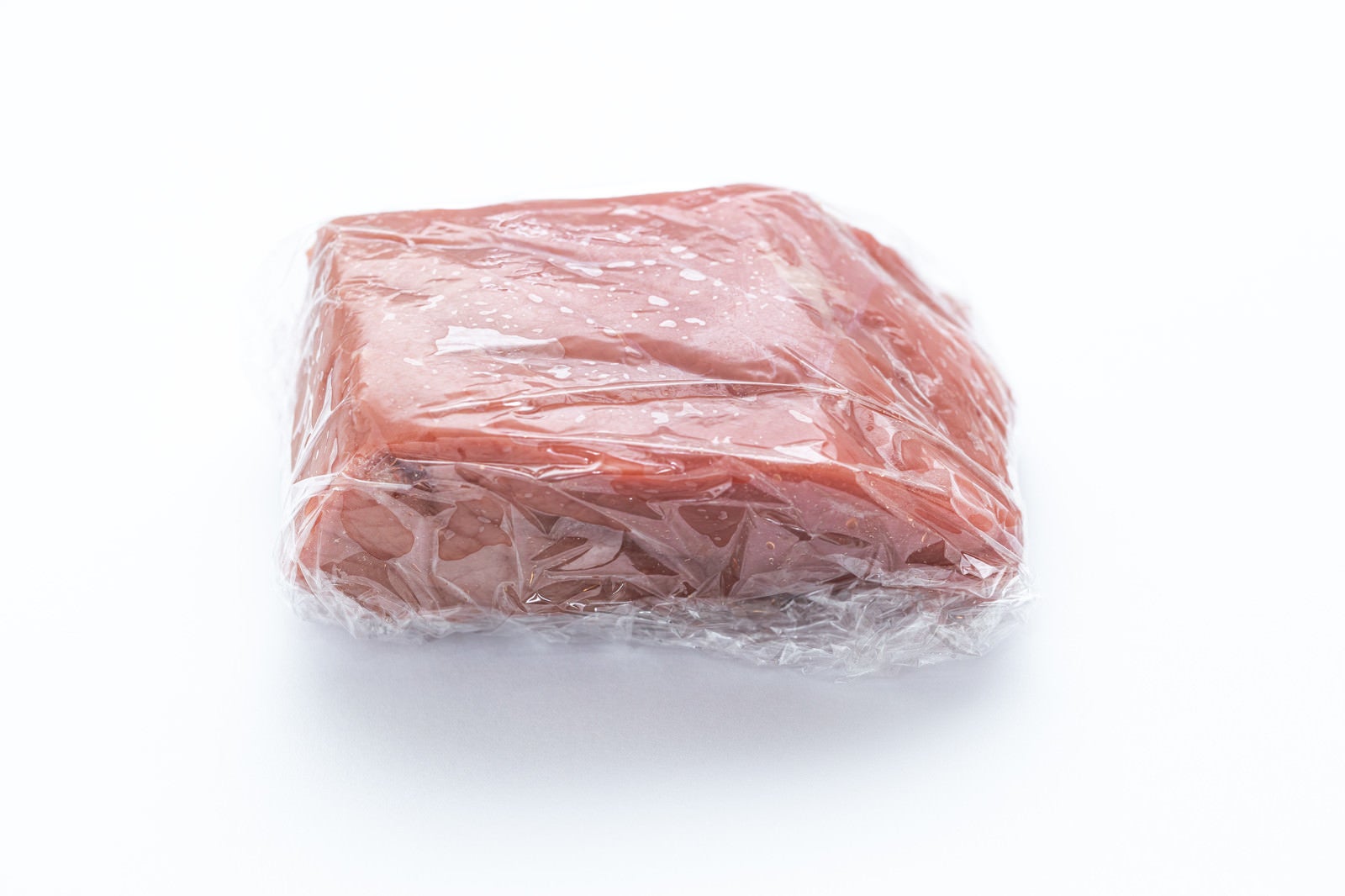 「食品用ラップフィルムに包まれたブロック肉」の写真