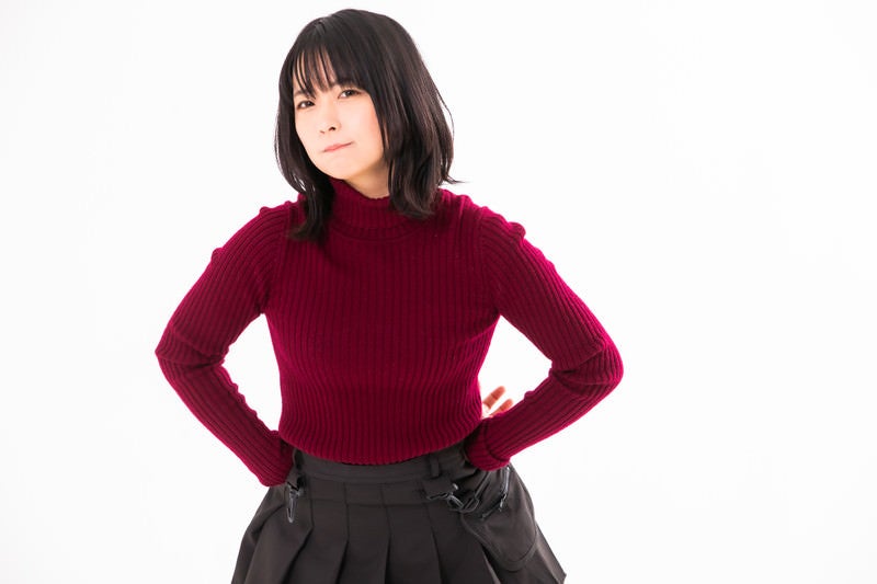 腰に手を当てて不機嫌そうな表情の女性の写真