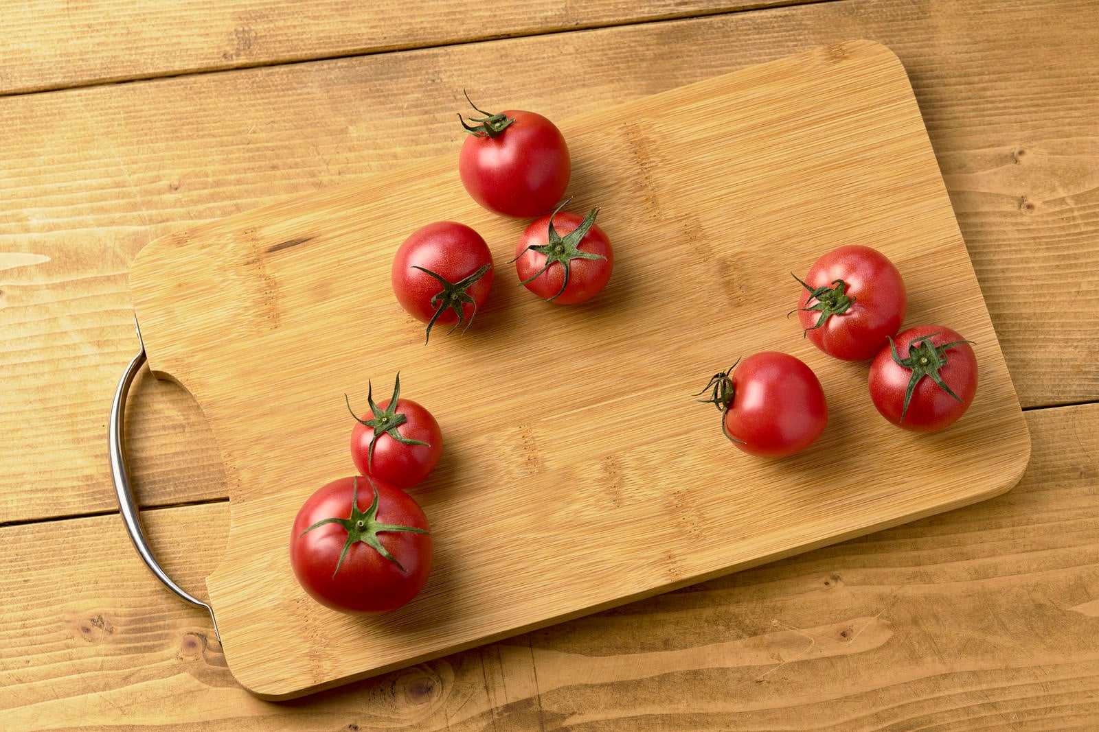 「まな板の上の蔕付きミニトマト」の写真