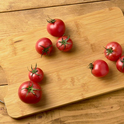 まな板の上の蔕付きミニトマトの写真