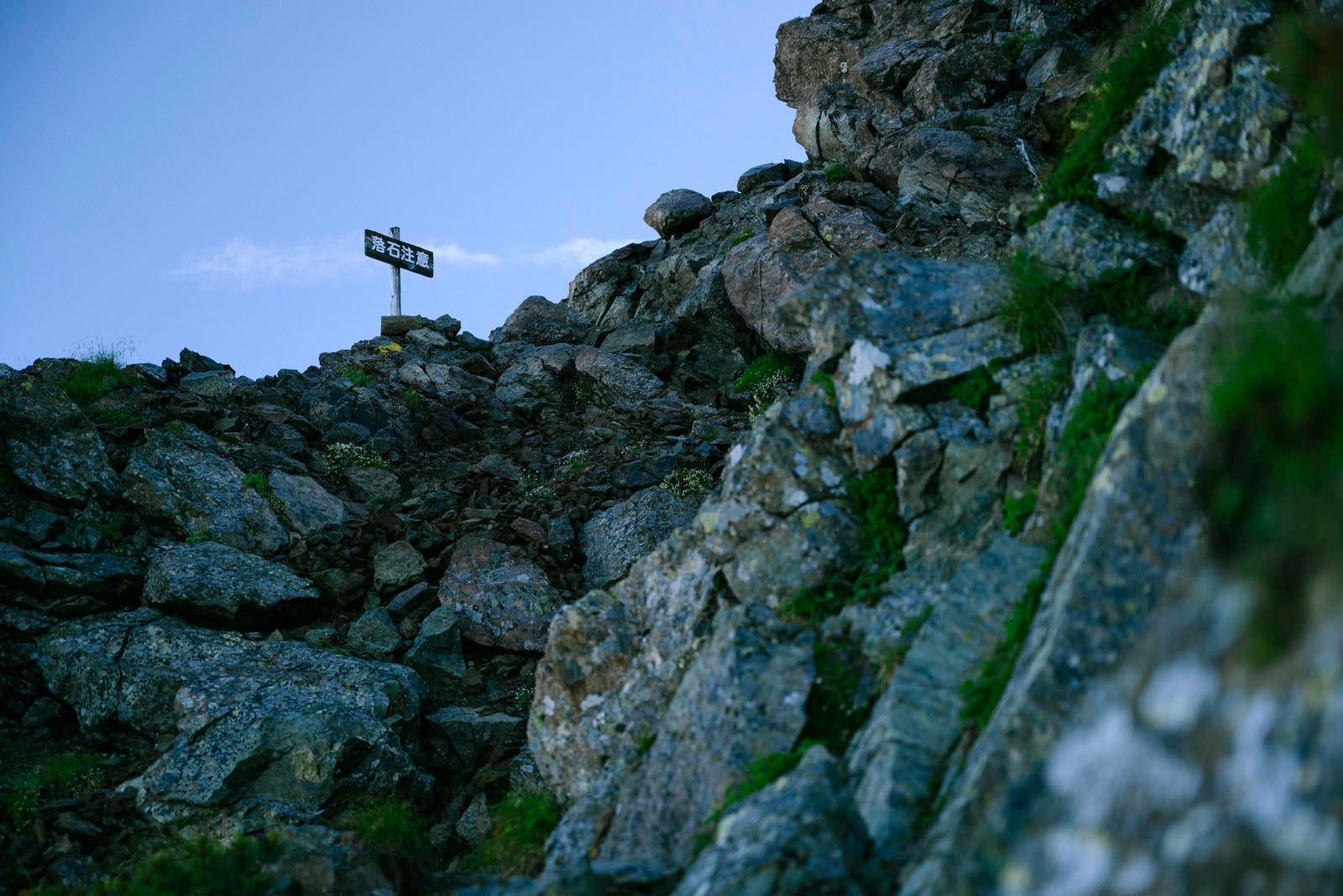 「岩場の上にある落石注意の看板」の写真