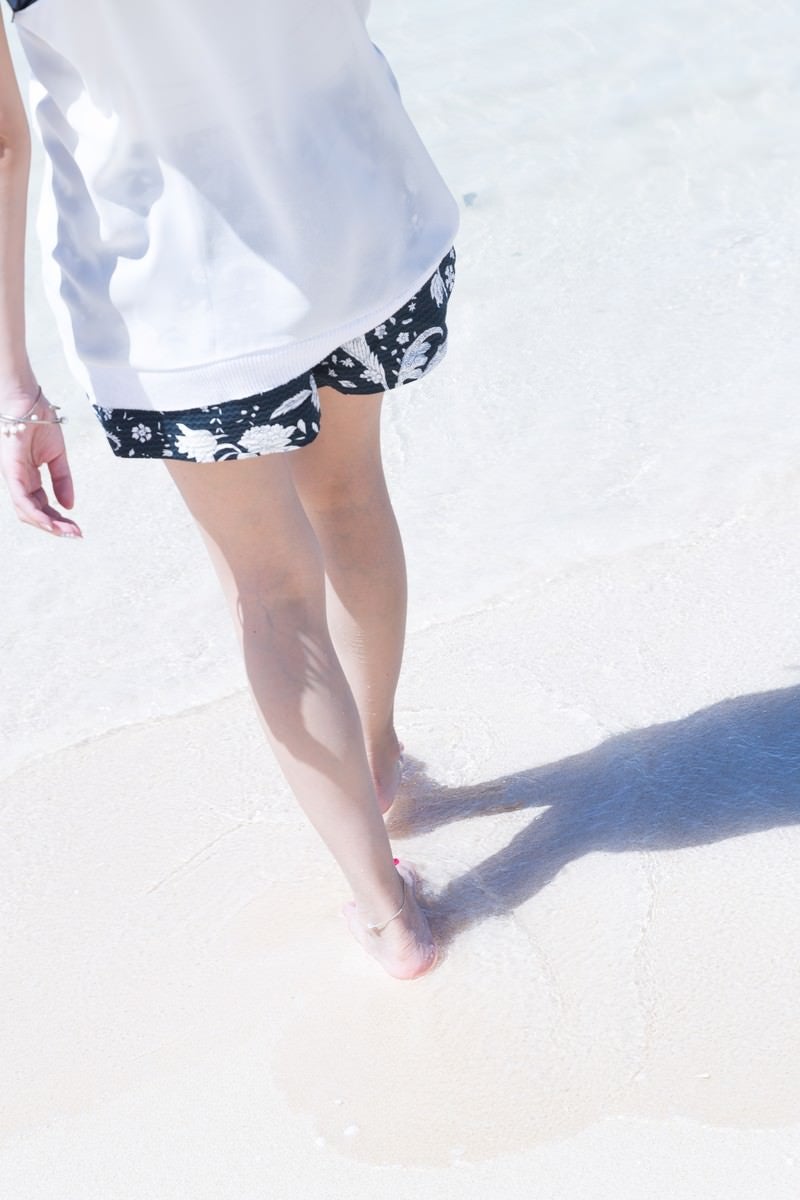 「水辺を歩く女性の足元」の写真