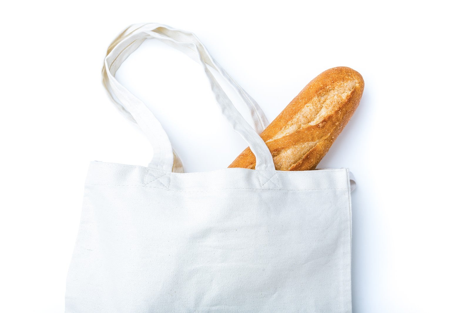 「無地のトートバッグに入ったフランスパン」の写真