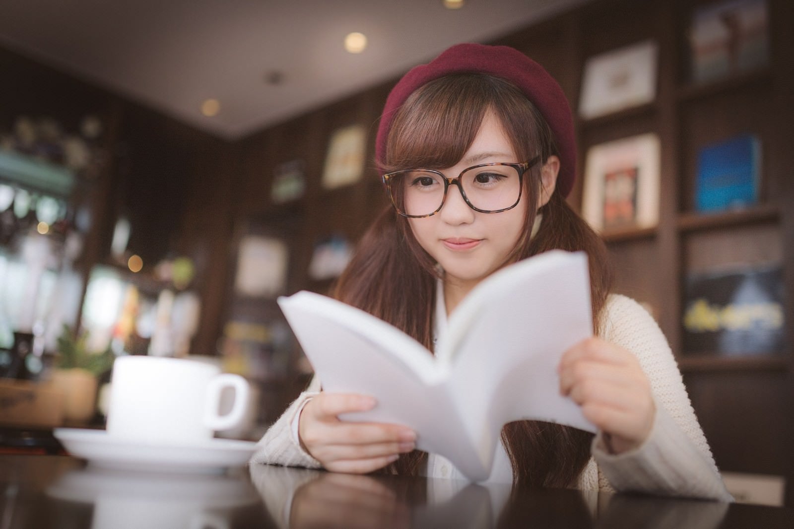 「カフェで調べ物をするメガネをかけた美少女」の写真［モデル：河村友歌］